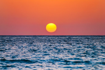 the sun is near the sea at caletta beach in the Island of San Pietro, Sardinia