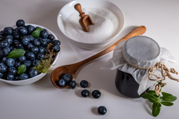 Huckleberry Jam close-up. Blueberry and sugar and wooden spoon in a bowl in the kitchen