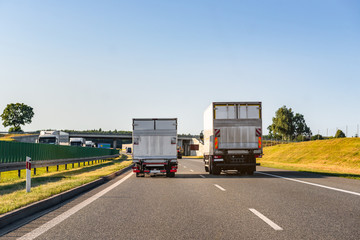 Freight trucks on a highway. Concept of safe driving. - obrazy, fototapety, plakaty