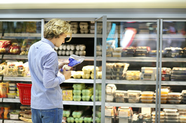 Man choosing frozen food from a supermarket freezer