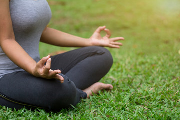 Woman do yoga outdoor, Yoga in the park, Close up hands, Concept of healthy lifestyle and relaxation.