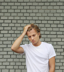 Teenager standing near a brick wall