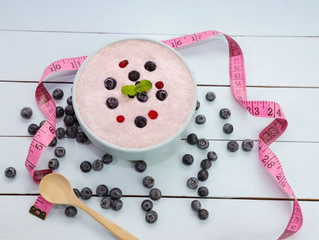 Yogurt with fresh of berries in blow and measuring on wooden background,diet concept