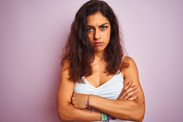 Obraz premium Young beautiful woman wearing white t-shirt standing over isolated pink background skeptic and nervous, disapproving expression on face with crossed arms. Negative person.