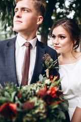 A young couple in wedding clothes on a sunny autumn day walk around the city. Emotions. Portrait of a happy husband and wife on a background of greenery. funny guy and girl are laughing outdoors.