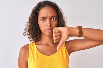 Young brazilian woman wearing t-shirt standing over isolated white background with angry face,...