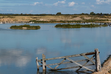 Fototapeta na wymiar A broken wooden gate on the waters edge, Rye