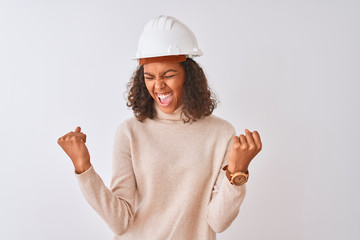 Young brazilian architect woman wearing security helmet over isolated white background very happy...