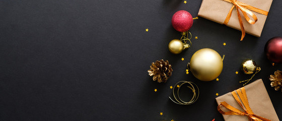 Christmas banner header. Black Xmas background with decorations, gifts box, balls, confetti, star. Christmas poster, greeting card template, hero banner mockup. Flat lay, top view, copy space