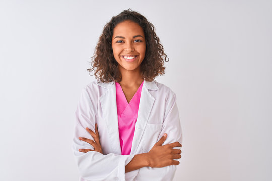 Young brazilian doctor woman wearing coat standing over isolated white background happy face smiling with crossed arms looking at the camera. Positive person.