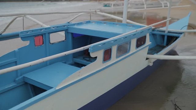 Philippines fish boat stands on the beach of Palawan island