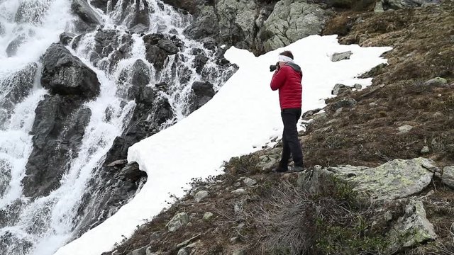 Photographer takes picture of waterfall near Susch pass near Davos in Switzerlang. Shot was made in slow motion in June.