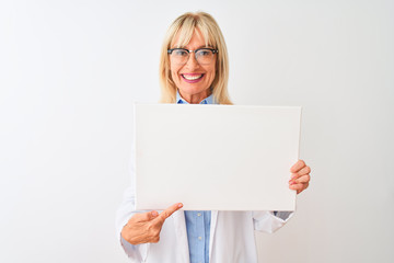 Fototapeta premium Middle age scientist woman wearing glasses holding banner over isolated white background very happy pointing with hand and finger