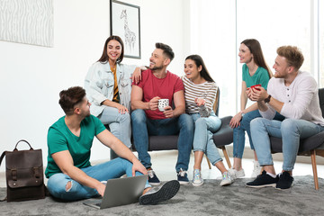 Group of happy people with laptop in living room