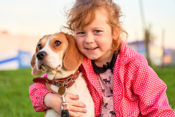 Adorable freckled girl hugs tenderly a cute puppy 