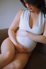 young pregnant woman stroking her tummy