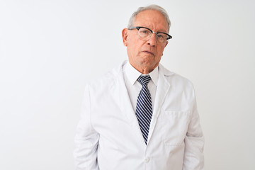 Senior grey-haired scientist man wearing coat standing over isolated white background with serious...
