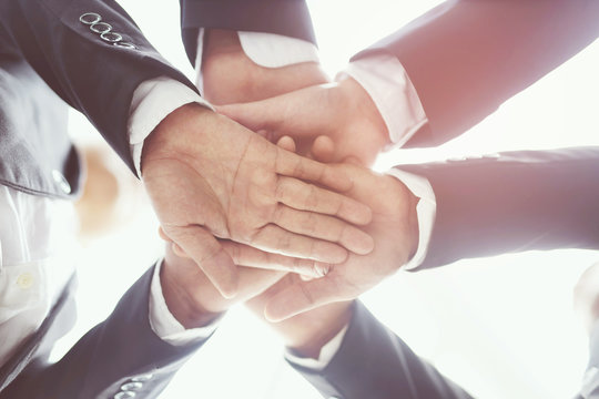 Close up of Group people of businessmen joining putting their hands together with stack of hands showing unity and teamwork. concept Success and encouragement to overcome obstacles. soft focus.