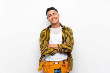 Young electrician man over isolated white wall looking up while smiling