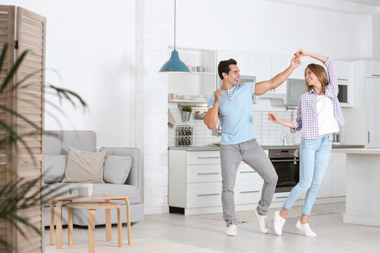 Beautiful Young Couple Dancing In Kitchen At Home