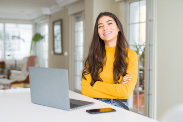 Young woman using computer laptop happy face smiling with crossed arms looking at the camera. Positive person.