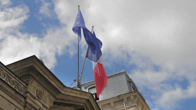 Flag of France and the European Union. Waves in the wind on a flagpole. Located on a traditional unrecognized French building. Slow Motion.