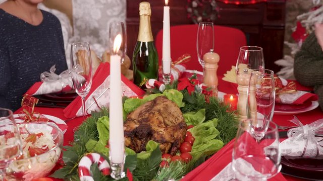 Adult woman putting down on the christmas table delicious turkey for her big family.