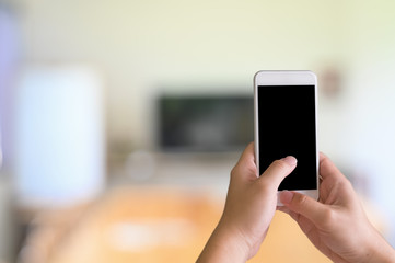 Closeup man hands using white smartphone and black display in blur meeting room.