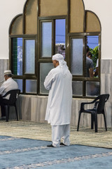 Obraz premium Muslim believer prays in prayer room of the Ahmadiyya Shaykh Mahmud mosque in Haifa city in Israel