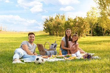 Happy family having picnic in park on sunny summer day