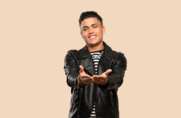 Young man holding copyspace imaginary on the palm to insert an ad over isolated background