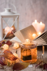 tea with books, candles, garland and autumn leaves