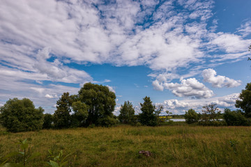 Fototapeta premium Volumetric clouds, green meadows and a lake on the territory of the monastery. Russian shrines. Joseph-Volotsky Monastery in Teryaev. Moscow region, Teryaevo.