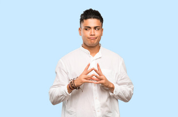 Young man scheming something on colorful background