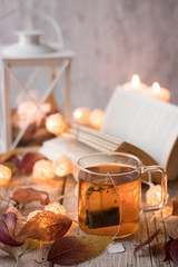 tea with books, candles, garland and autumn leaves