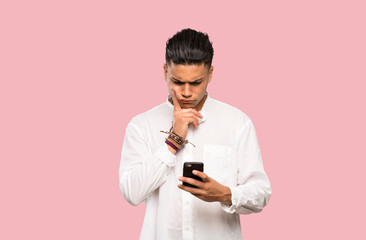 Young man thinking and sending a message on colorful background