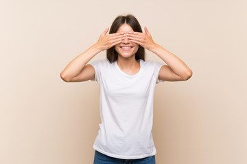 Pretty young girl over isolated background covering eyes by hands