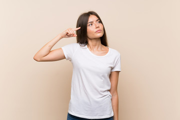 Pretty young girl over isolated background making the gesture of madness putting finger on the head