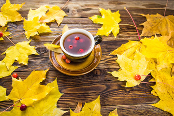 Yellow fallen maple leaves on wooden texture background.