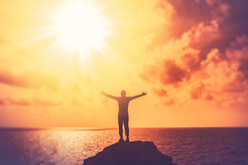 Copy space of happy man hand raise on top mountain at tropical beach and sunset sky abstract background.