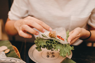 Vietnamese Pork Sausage and salad OR Nam-Neaung in hand on blur background vietnam food traditional