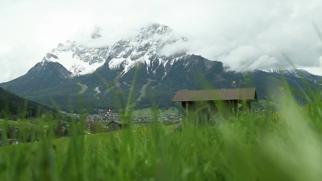 Green Alps grass fields and snow mountains of Austrian Lermoos. Filmed in slow motion in May.