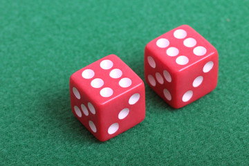 Red dice on a table with green cloth