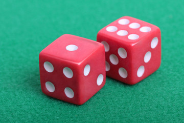 Red dice on a table with green cloth