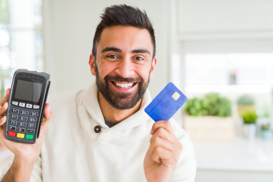 Business man smiling and holding point of sale terminal and credit card, contacless transaction
