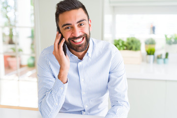 Handsome hispanic business man having a conversation talking on smartphone with a happy face...