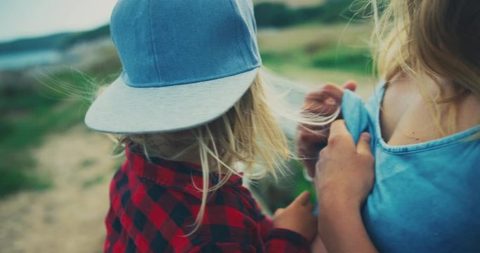 Young mother breasfeeding her toddler on a bench in nature