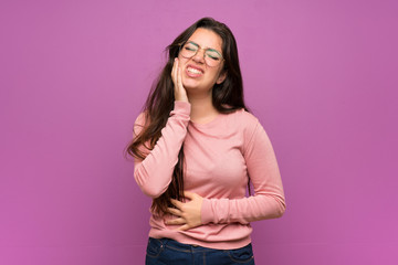 Fototapeta premium Teenager girl over purple wall with toothache