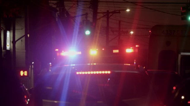 An ambulance with bright lights glaring at the scene of an altercation