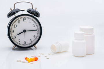 Fototapeta na wymiar Pills, capsules and alarm clock